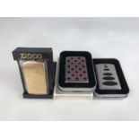 Three cased Zippo lighters, including 20429 Cherry Plaidness Emblem (not in original box) and one