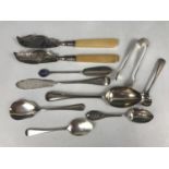 A quantity of silver cutlery including butter knives, sugar tongs, commemoratives and a Georgian