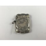 A George V silver vesta case, of cusped rectangular form, profusely engraved with foliage