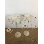 A pair of cream four-branch wrought iron floristry stands / candelabra