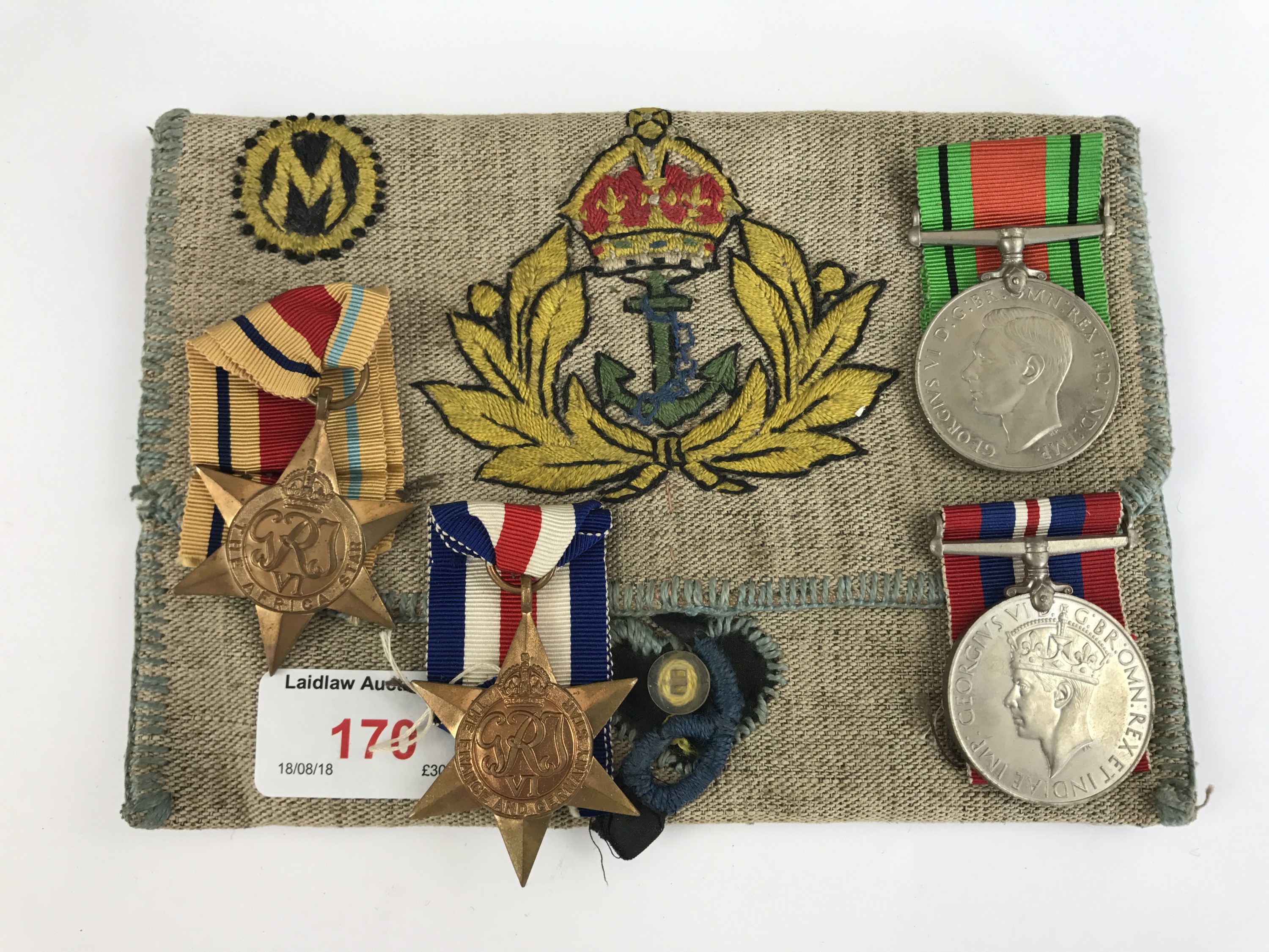 A Second World War Royal Navy campaign medal group together with a related hand-embroidered pouch