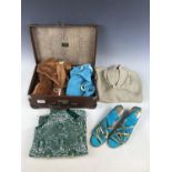 A vintage travel case containing two 1960s velour playsuits, a sequinned shift top, a gold lame