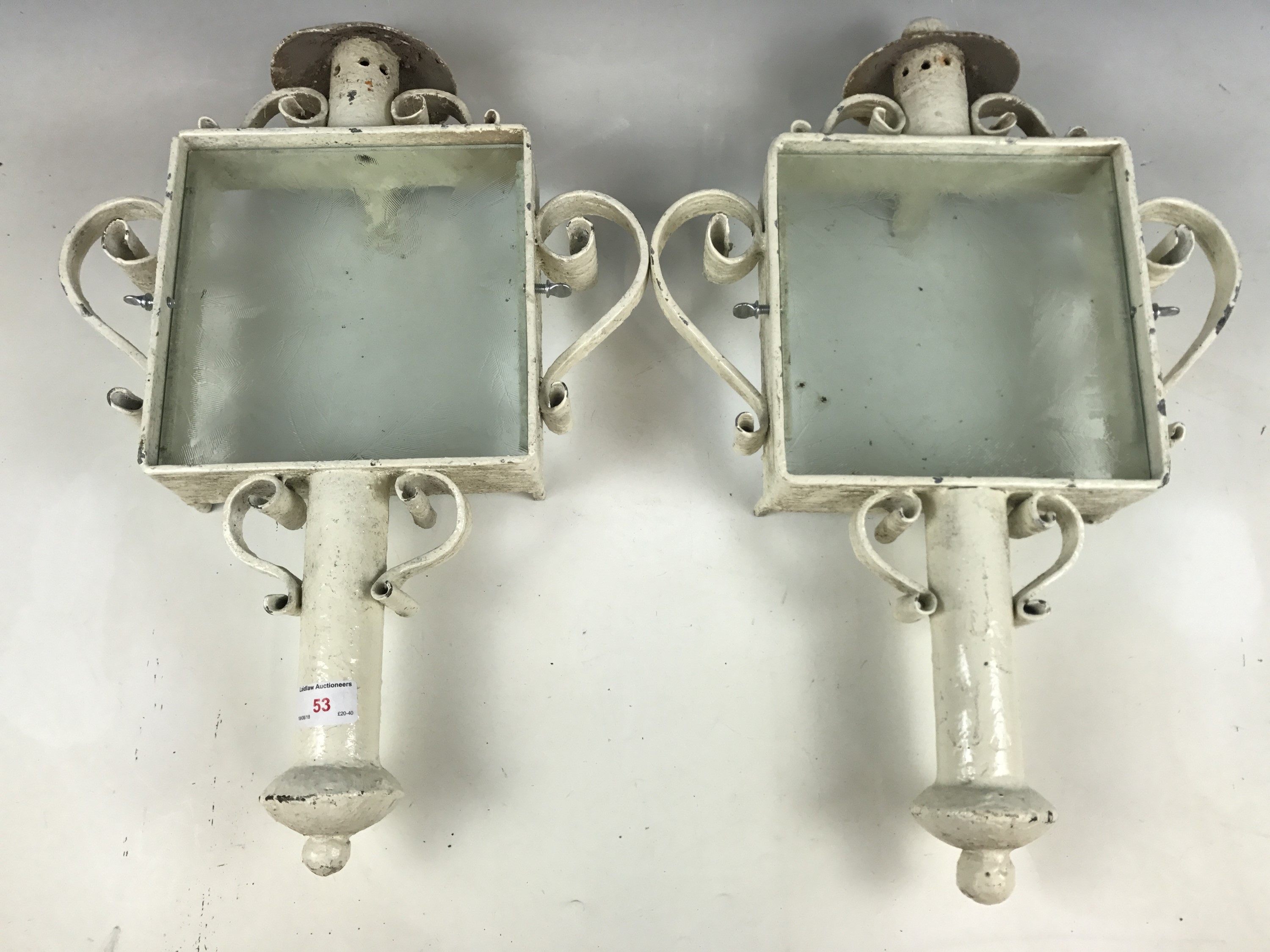 Two wrought-iron and glass exterior light sconces