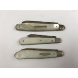 Three silver folding fruit knives with mother of pearl grip scales