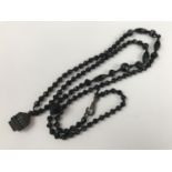 A Victorian Whitby jet pendant necklace carved in depiction of "Alston Cross" and suspended on a