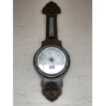 An early 20th Century carved oak banjo barometer