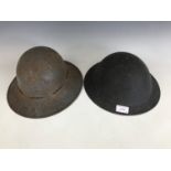 A Second World War British Civil Defense steel helmet together with a Fire Watcher's helmet