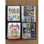 Four collectors' albums of trading cards including Disney and Upper Deck Looney Tunes etc