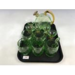 An emerald green decanter with glasses, together with five further emerald green glass cups