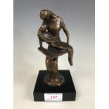 A contemporary "Bronzeart" sculpture of a mother reading a story book to her slumbering child,