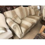 A contemporary two-seater beige and mocha upholstered sofa