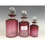 Three late Victorian mould-blown achromatising cranberry glass toiletry jars, having ground in