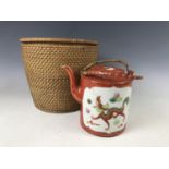 A Chinese tea pot in insulated rattan basket