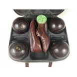 A cased set of Bakelite Henselite indoor bowls with a pair of bowling shoes