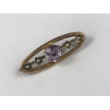 A Belle Epoque amethyst and seed pearl openwork bar brooch, of lenticular form, surmounted by