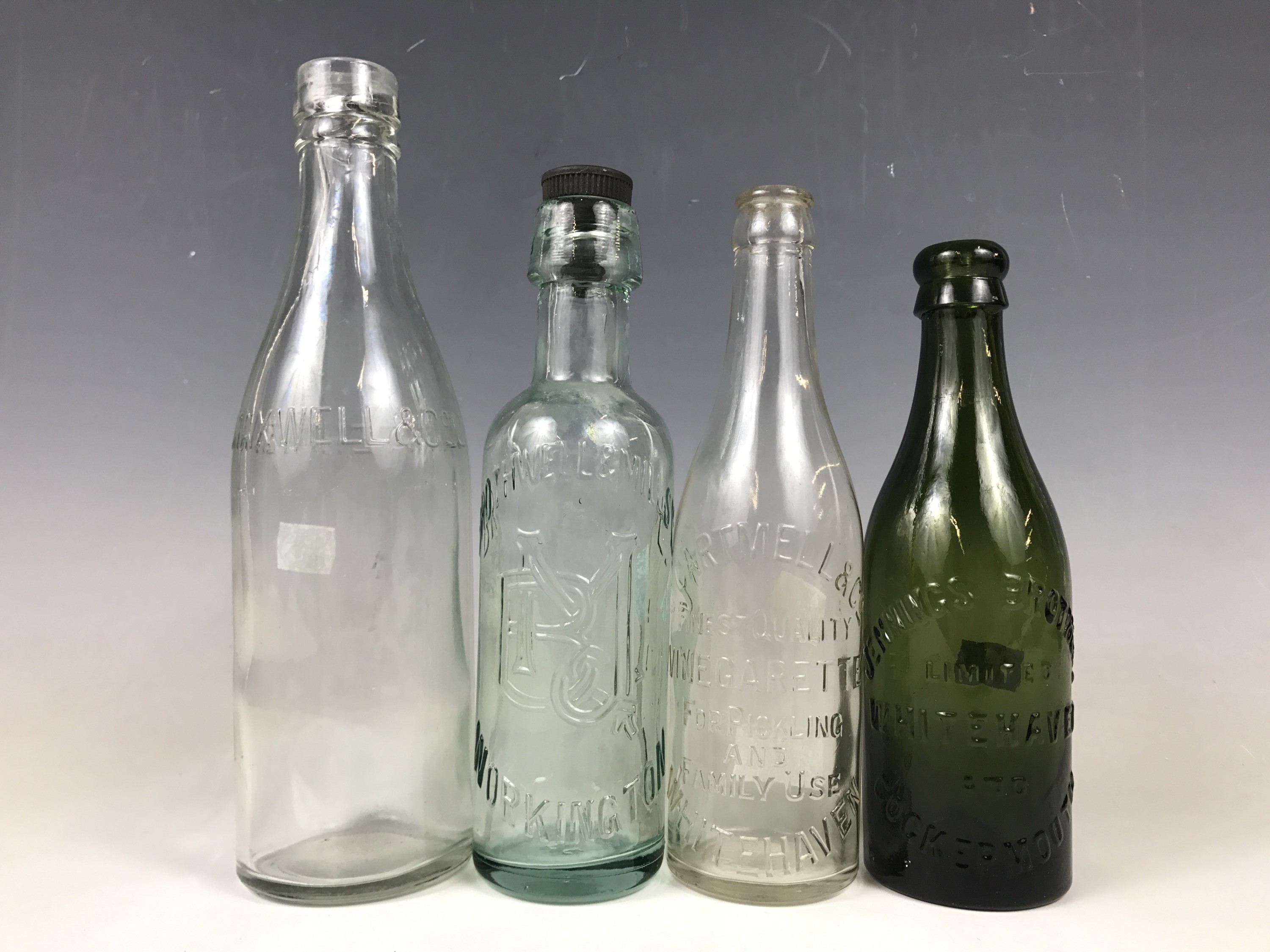 Four various Cumbrian glass bottles