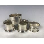 Four Edwardian and later silver napkin rings, including a pair of George V silver napkin rings (a/