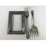 An antique silver photograph frame and two silver forks