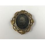 A Victorian gilt metal locket brooch with inset early portrait photograph