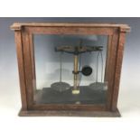 An early 20th Century analytical balance by Thomson, Skinner & Hamiltion of Glasgow, in glazed oak