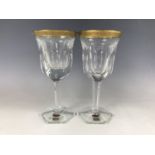A pair of Moser crystal wine goblets, having gilded and engraved rims, on faceted stems, 21 cm