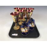 A set of six cranberry gilded and encrusted glasses together with a pair of brandy glasses