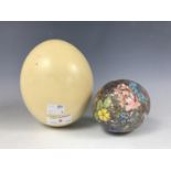 An ostrich egg, together with one other plaster of Paris egg having hand-painted decoration