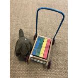 Vintage toys including a Tri-ang baby walker containing painted wooden bricks and a soft toy