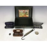 A metal cash box together with pince-nez, spectacles, a pocket balance and a vintage game