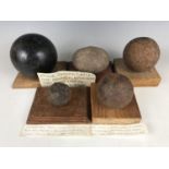 Four various iron cannon balls and a Roman stone catapult shot