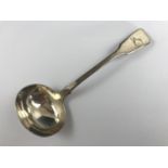 A Victorian Irish silver fiddle-pattern sauce ladle, the terminal engraved with an armorial crest in