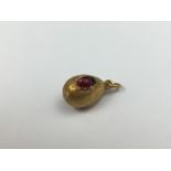 A high-carat yellow-metal, diamond and ruby egg form pendant, possibly by Faberge, having a