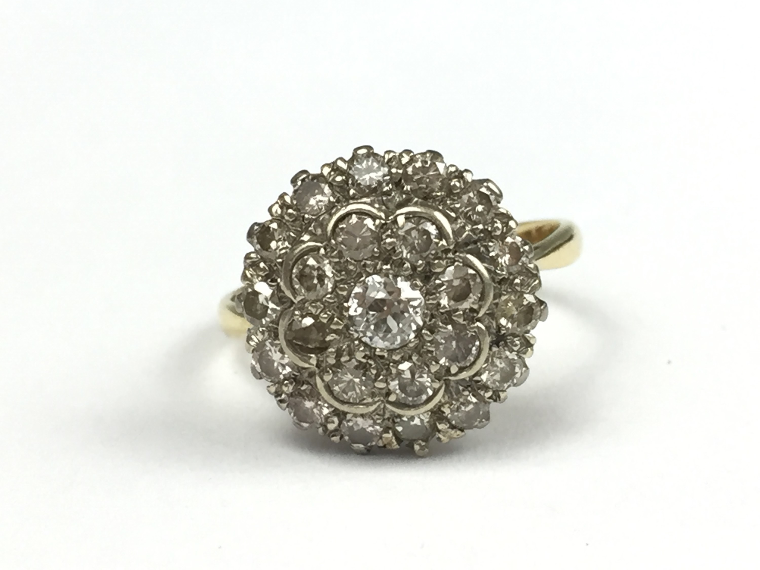 A vintage diamond flower head cluster ring, comprising two tiers of pellet-set brilliant-cut