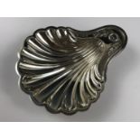 A George V silver butter dish in the form of a scallop shell, the thumb-piece having laurel leaf and