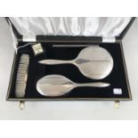 An Elizabeth II cased silver four-piece dressing table set, comprising hand mirror, hair brush, comb