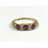 An Edwardian ruby and diamond ring, comprising three oval-cut rubies divided by pairs of diamond