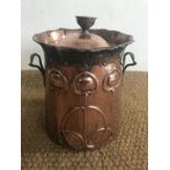 A late 19th Century Arts and Crafts copper coal bucket, decorated with stylized blooms atop whiplash