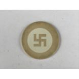 A pre-Second World War poker chip bearing a swastika device