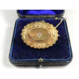 A Victorian Etruscan Revival diamond locket-back brooch, the cushion-cut brilliant of