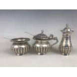 A white-metal three piece cruet set, having half gadrooned decoration, stamped 'sterling silver',