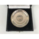 An Edward VII 1906 silver rupee coin inset to the centre of a white-metal dish, stamped 'silver',