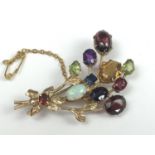 A modern 9ct gold gemstone specimen brooch modelled as a ribbon-tied bouquet of blossoms, the '