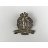 A Scottish cap badge, within oak sprays the winged figure of Victory with shield and sword and