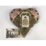 A First World War sweetheart pin cushion centred by a printed card bearing the emblem of the