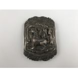 A South Asian white metal buckle, decorated in a high relief depiction of a Chinthe or temple