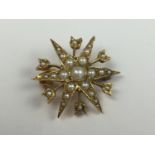 An antique 9ct gold and seed pearl brooch modelled in the form of a star burst, the points being