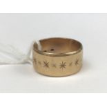 A 9ct gold wedding band, the broad face decorated with a band of bright-cut stars, 7g