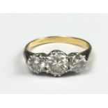 A three-stone diamond ring, comprising a central brilliant of .5 ct flanked by two .25 ct stones,