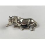 A miniature white-metal statuette of a recumbent horse, tests as silver, 16.8g, 2 cm high