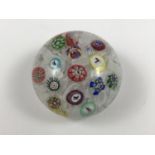 A Baccarat spaced millefiori paperweight, comprising a cane dated 1848 and others bearing